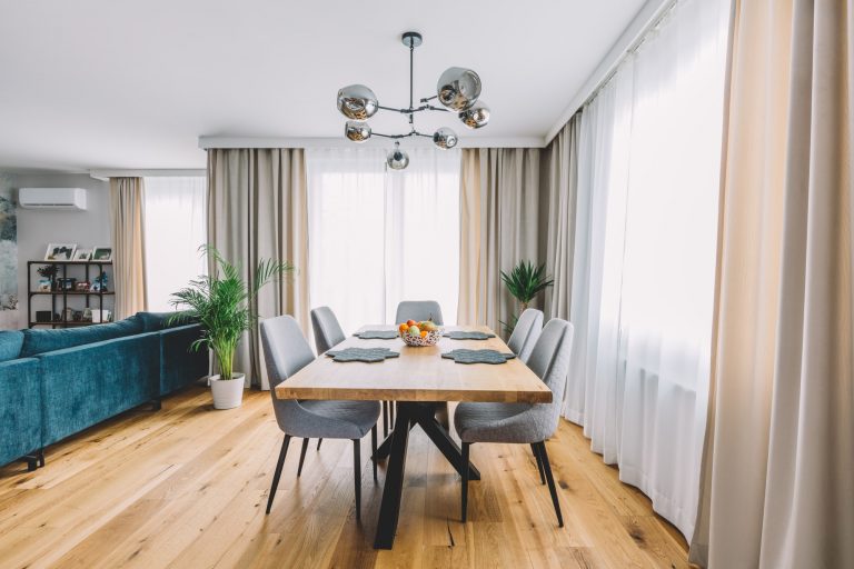 An image of dining room with wooden table and floor in modern apartment put on by Palouse Floors
